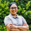Hina arms crossed, smiling, in mason polo