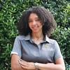 Hailey in a grey mason polo smiling, arms crossed